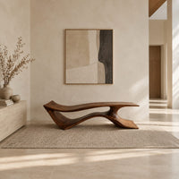 Long low bench with a wave shaped plank seat on a swept base in a bright open plan entryway