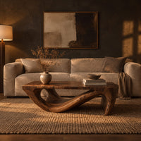 Rectangular coffee table with a thick top over a swooping open loop base in a dark living room at golden hour
