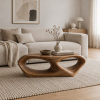 Sculpted coffee table with two large oval openings and a smooth low body in a Scandinavian living room with white walls