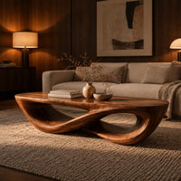 Coffee table with a twisting figure eight base and a thick oval top in an evening living room with walnut wall paneling