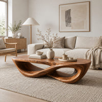 Coffee table with a twisting figure eight base and a thick oval top in a Scandinavian living room with white walls