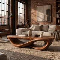 Coffee table with a twisting figure eight base and a thick oval top in an industrial loft living room with exposed brick