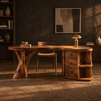 Kidney shaped wood desk with a tree trunk leg and a drawer pedestal in a dark home office at golden hour