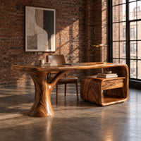 Sculpted desk with a tree trunk leg and a loop frame side unit in an industrial loft home office with exposed brick
