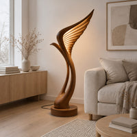 Tall floor lamp shaped like a ribbed feather wing on a round wooden base in a Scandinavian living room with white walls