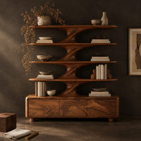 Corner detail of bookshelf with sculpted flared tiers on a low base with three front panels beside wood, brass and linen samples