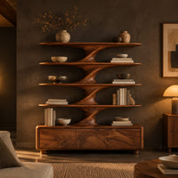 Bookshelf with sculpted flared tiers on a low base with three front panels in a dark living room at golden hour