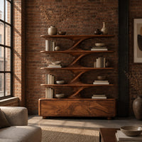 Bookshelf with sculpted flared tiers on a low base with three front panels in an industrial loft living room with exposed brick