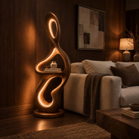 Sculpted floor lamp with glowing oval cutouts and a mid level shelf in an evening living room with walnut wall paneling