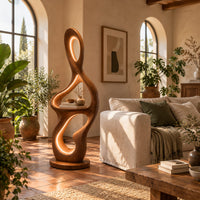 Sculpted floor lamp with glowing oval cutouts and a mid level shelf in a bright living room with arched windows and plants