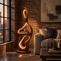 Sculpted floor lamp with glowing oval cutouts and a mid level shelf in an industrial loft living room with exposed brick