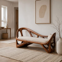 Sculpted wooden bench with open branching sides and a padded seat in a Scandinavian entryway with white walls