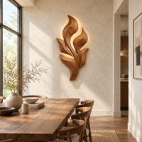 Sculpted wooden leaf cluster wall art in layered shapes beside a dining table in natural light