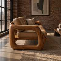 Three seat sofa with tufted cushions and open loop wooden arms in an industrial loft living room with exposed brick