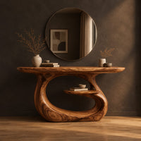 Oval top makeup vanity on a looping pedestal base with a small inner shelf in a dark studio against a charcoal plaster wall