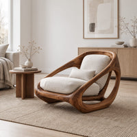 Sculpted lounge chair with a thick looping wood frame and open side cutouts in a Scandinavian living room with white walls
