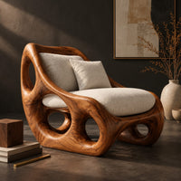 Corner detail of lounge chair with circular side cutouts and a high back with cream cushions beside wood, brass and linen samples
