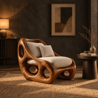 Lounge chair with circular side cutouts and a high back with cream cushions in a dark living room at golden hour