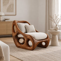 Lounge chair with circular side cutouts and a high back with cream cushions in a Scandinavian living room with white walls