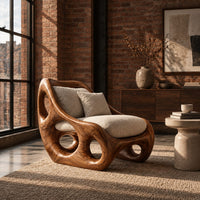 Lounge chair with circular side cutouts and a high back with cream cushions in an industrial loft living room with exposed brick
