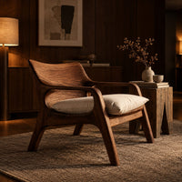 Lounge chair with looped arms and a swept wooden back in an evening living room with walnut wall paneling