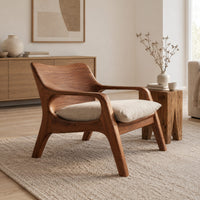 Lounge chair with looped arms and a swept wooden back in a Scandinavian living room with white walls