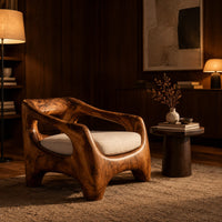 Sculpted wooden lounge chair with open arm cutouts and a cream seat cushion in an evening living room with walnut wall paneling