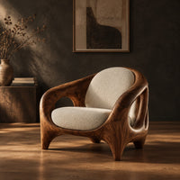 Sculpted lounge chair with an open cutout wood frame and cream cushions in a dark studio against a charcoal plaster wall