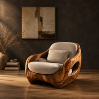 Sculpted lounge chair with open oval side cutouts and a cushioned seat in a dark studio against a charcoal plaster wall