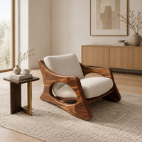 Sculptural lounge chair with oval side cutouts and a cushioned seat in a Scandinavian living room with white walls