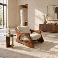Sculptural lounge chair with oval side cutouts and a cushioned seat in a bright open plan living room