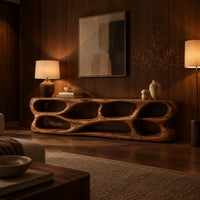 Free form tv stand made of thick sculpted wood with many oval openings in an evening living room with walnut wall paneling
