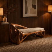 Bench with a sculpted open frame, a cushioned seat and a raised end in an evening entryway with walnut wall paneling