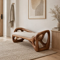 Bench with a sculpted open frame, a cushioned seat and a raised end in a Scandinavian entryway with white walls