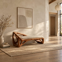 Bench with a sculpted open frame, a cushioned seat and a raised end in a bright open plan entryway