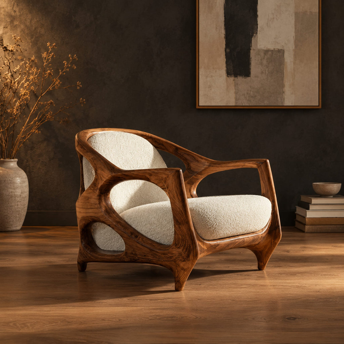 Sculpted lounge chair with an open oval wooden frame and cream cushions in a dark studio against a charcoal plaster wall