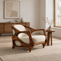 Sculpted lounge chair with an open oval wooden frame and cream cushions in a Scandinavian living room with white walls