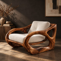 Sculpted wooden armchair with open oval side loops and cream cushions, three-quarter view showing the grain