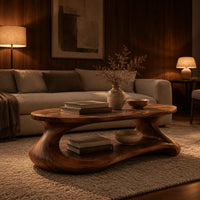 Coffee table with a sculpted pebble base and low shelf in an evening living room with walnut wall paneling