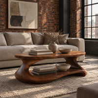 Coffee table with a sculpted pebble base and low shelf in an industrial loft living room with exposed brick