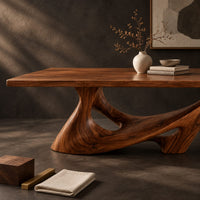 Corner detail of dining table with a slab top on a sculpted pedestal with open cutouts beside wood, brass and linen samples