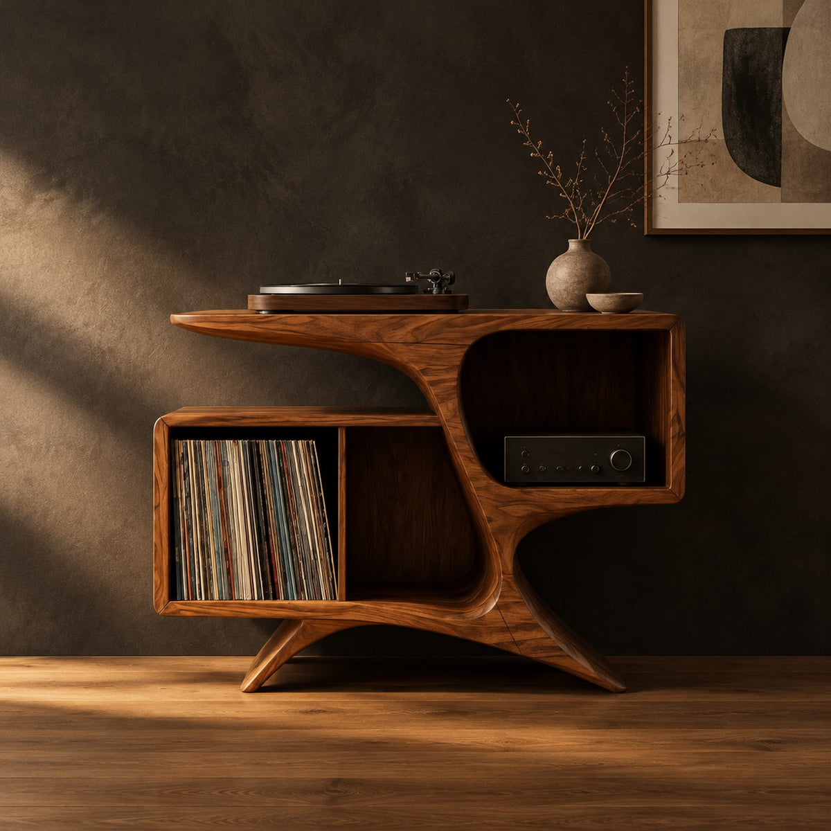 Sculpted wood record console with swooping legs and open bays in a dark studio against a charcoal plaster wall
