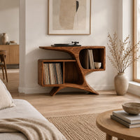 Sculpted wood record console with swooping legs and open bays in a Scandinavian living room with white walls