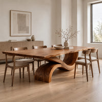 Dining table with a long plank top and one sweeping ribbon base in a Scandinavian dining room with white walls