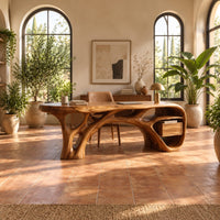 Sculptural desk with a flowing top, branching root base and open end niche in a bright home office with arched windows and plants