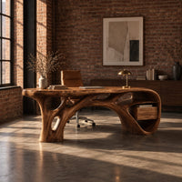 Sculptural desk with a flowing top, branching root base and open end niche in an industrial loft home office with exposed brick