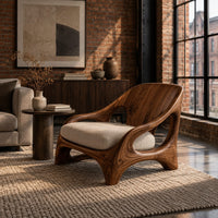 Sculpted wooden chair with oval openings and broad arched legs in an industrial loft living room with exposed brick