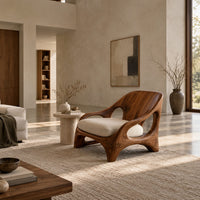 Sculpted wooden chair with oval openings and broad arched legs in a bright open plan living room