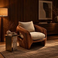 Sculpted wooden shell chair with an oval side opening and cream cushions in an evening living room with walnut wall paneling
