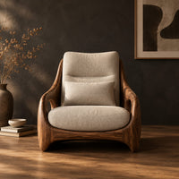 Sculpted lounge chair with oval side cutouts and a cushioned seat in a dark studio against a charcoal plaster wall